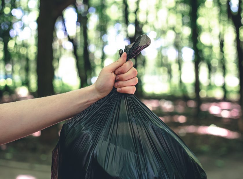 Close-up, a bag of garbage on a blurred background of the forest.