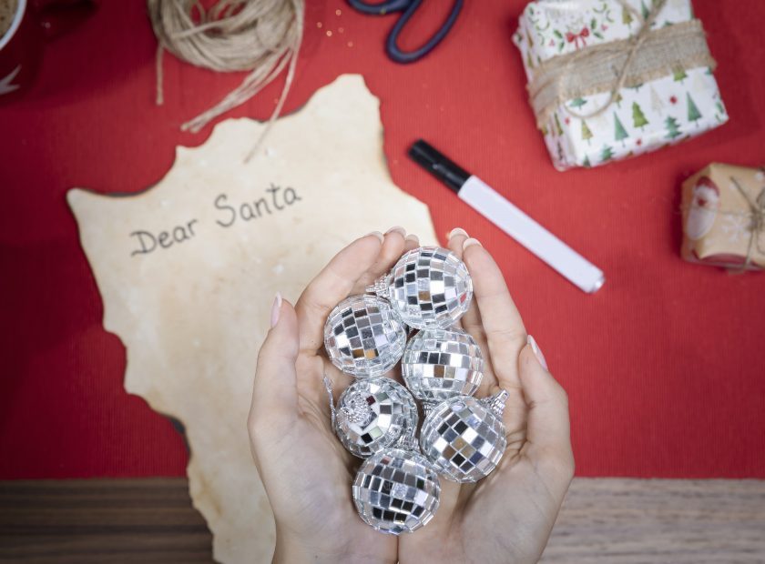 vista-superior-manos-con-globos-de-navidad